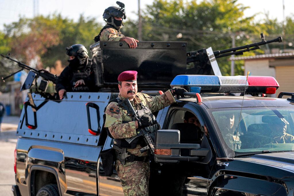 Combatientes del grupo paramilitar Hashed Al Shaabi resguardan el funeral de Hassan Hammadi Al-Amiri durante ataque de Estados Unidos sobre Irak.