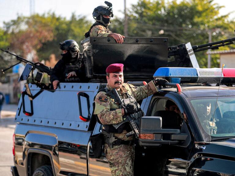 Combatientes del grupo paramilitar Hashed Al Shaabi resguardan el funeral de Hassan Hammadi Al-Amiri durante ataque de Estados Unidos sobre Irak.