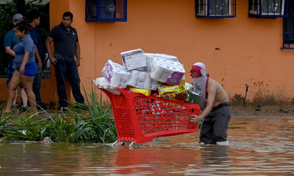 Hombre en medio de una calle inundada en Acapulco de México