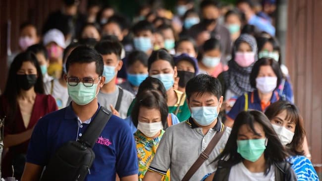 Commuters wearing protective face masks walk on Pratunam pier in Bangkok on April 26, 2021, after the government imposed strict restrictions including a 20,000 THB (525 Euros, 636 USD) fine for not wearing a mask in public following the recent outbreak of Covid-19 coronavirus cases in Thailand. (Photo by Mladen ANTONOV / AFP) (Photo by MLADEN ANTONOV/AFP via Getty Images)