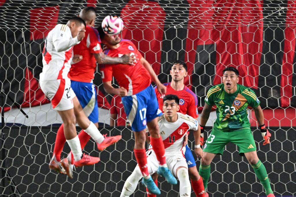 TOPSHOT - Chile's goalkeeper #23 Brayan Cortes, defender #14 Felipe Loyola and Peru's forward #11 Jose Rivera react as Peru's midfielder #20 Edison Flores, Chile's midfielder #08 Arturo Vidal and defender #17 Gabriel Suazo jump for the ball during the 2026 FIFA World Cup South American qualifiers football match between Peru and Chile at the National stadium in Lima on November 15, 2024. (Photo by CRIS BOURONCLE / AFP) (Photo by CRIS BOURONCLE/AFP via Getty Images)
