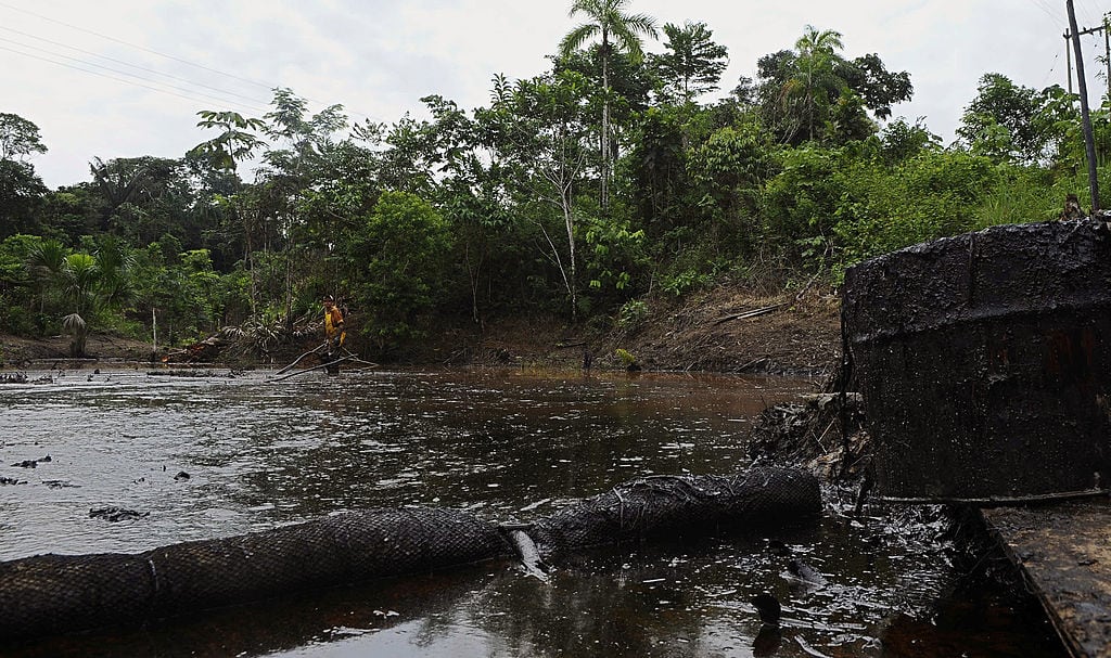 Un trabajador de la empresa estatal Petroecuador intenta limpiar el crudo que se derramara en un afluente en Ecuador.