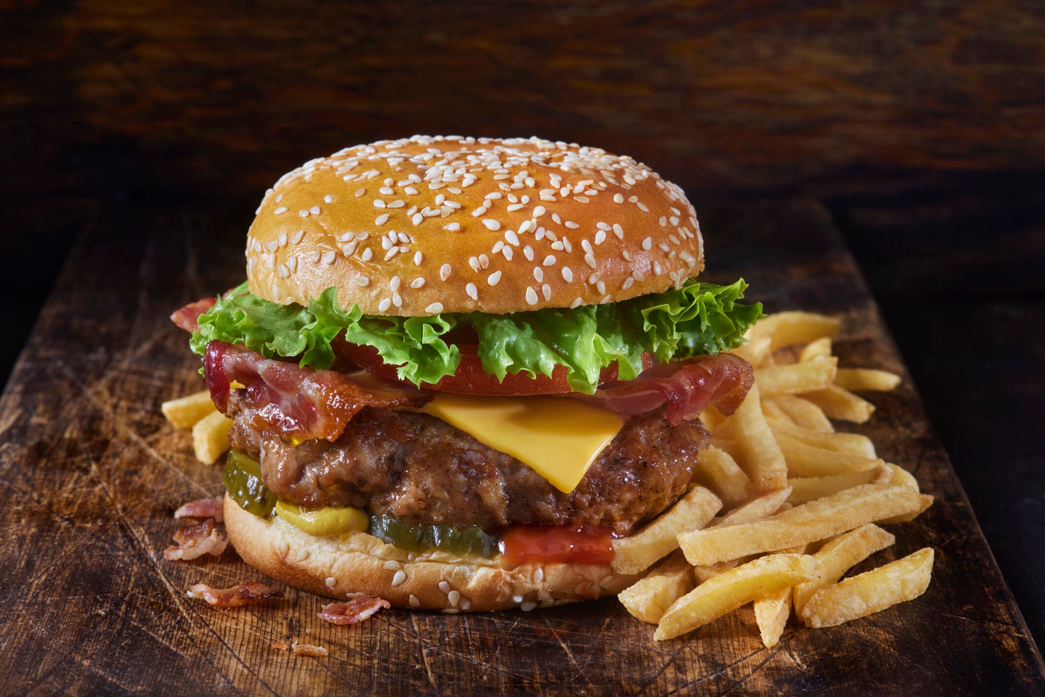 Grilled Juicy Ground PORK and Bacon Cheeseburger with Lettuce, Tomato, Pickles, Ketchup, Mustard and Fries
