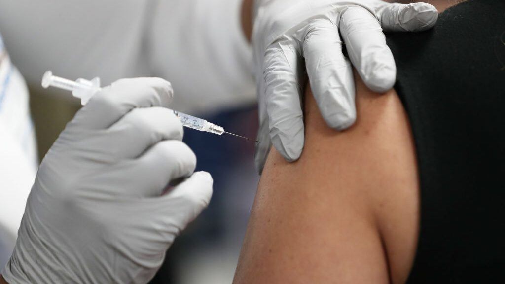 MIAMI, FLORIDA - DECEMBER 15: A healthcare worker at the Jackson Health Systems receives a Pfizer-BioNtech Covid-19 vaccine from Susana Flores Villamil, RN from Jackson Health Systems, at the Jackson Memorial Hospital on December 15, 2020 in Miami, Florida. Jackson Memorial Hospital began the vaccination of frontline healthcare workers joining with hospital systems around the country as the COVID-19 vaccine is rolled out. (Photo by Joe Raedle/Getty Images)