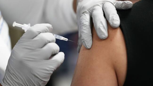 MIAMI, FLORIDA - DECEMBER 15: A healthcare worker at the Jackson Health Systems receives a Pfizer-BioNtech Covid-19 vaccine from Susana Flores Villamil, RN from Jackson Health Systems, at the Jackson Memorial Hospital on December 15, 2020 in Miami, Florida. Jackson Memorial Hospital began the vaccination of frontline healthcare workers joining with hospital systems around the country as the COVID-19 vaccine is rolled out. (Photo by Joe Raedle/Getty Images)