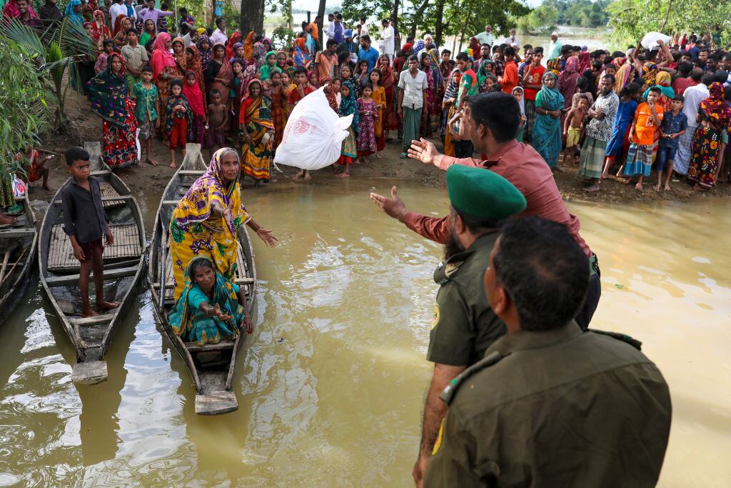 Soldados ayudan a mujeres y niños atrapadas por la inundación en Bangladesh