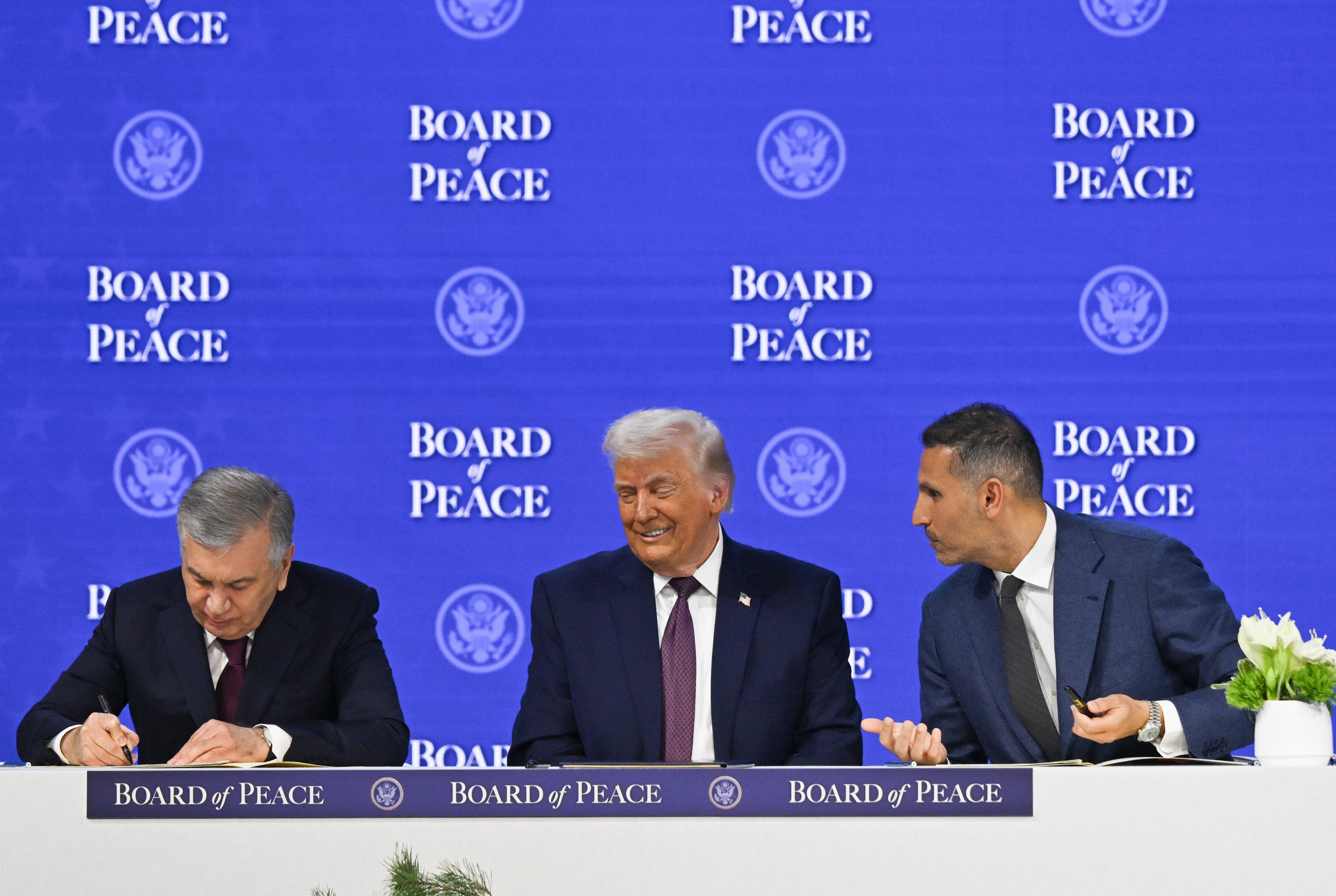 DAVOS, SWITZERLAND - JANUARY 22: US President Donald Trump (C) and Uzbekistan President Shavkat Mirziyoyev (L) attend the signing ceremony of the Peace Charter for Gaza as part of the 56th World Economic Forum in Davos, Switzerland on January 22, 2026. (Photo by Harun Ozalp/Anadolu via Getty Images)