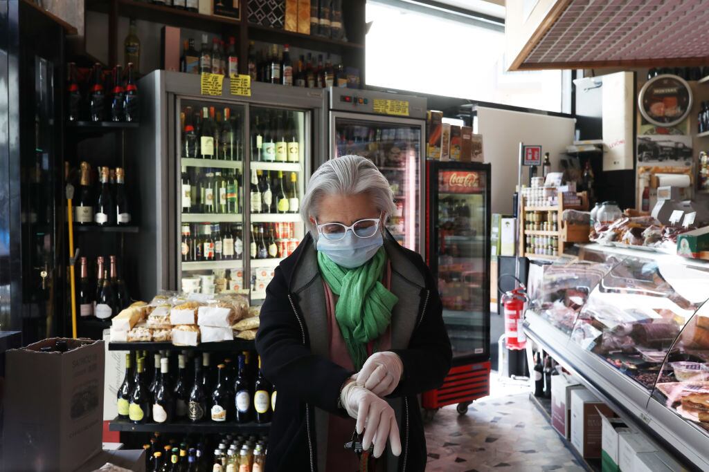 Una mujer ingresa a comprar a un mercado de la ciudad de Roma en Italia