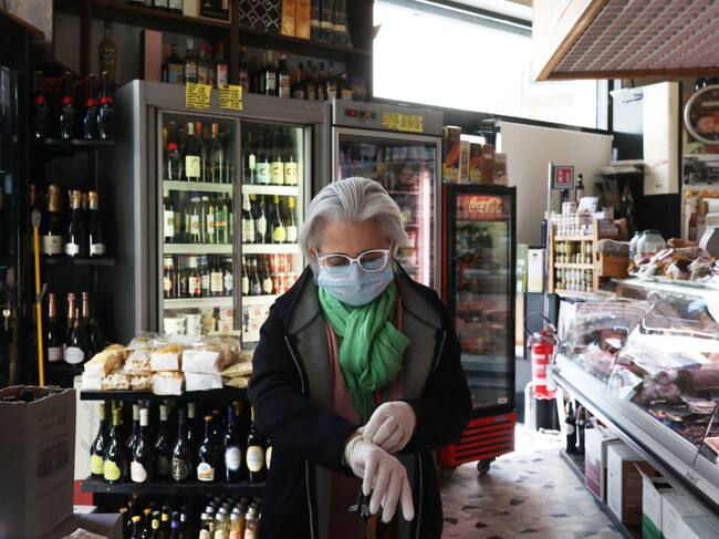 Una mujer ingresa a comprar a un mercado de la ciudad de Roma en Italia