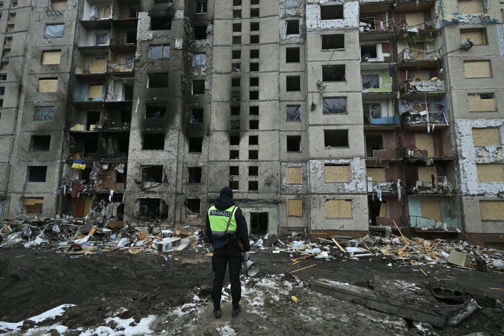 Un policía observa el daño que deja un ataque aéreo de Rusia en un edificio de la región de Kiev en Ucrania.