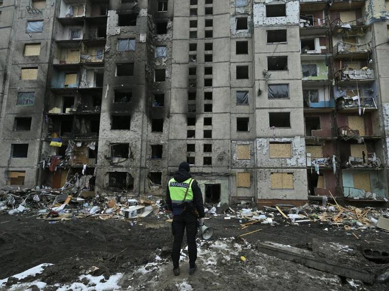 Un policía observa el daño que deja un ataque aéreo de Rusia en un edificio de la región de Kiev en Ucrania.