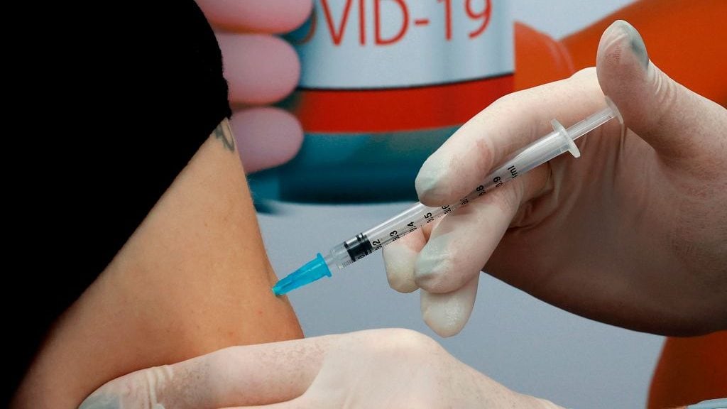 A Israeli woman gets vaccinated against COVID-19 coronavirus at Clalit Health Services in the Israeli coastal city of Tel Aviv, on December 23, 2020. - Israel has ordered 14 million coronavirus vaccine doses -- covering seven million people, as two doses are required per person -- from US pharmaceutical giant Pfizer and US biotech firm Moderna. (Photo by JACK GUEZ / AFP) (Photo by JACK GUEZ/AFP via Getty Images)