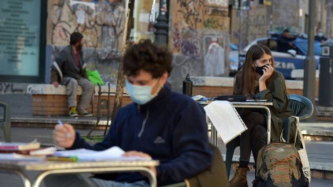 ROME, ITALY - NOVEMBER 03: University students are studying in the square in the San Lorenzo neighborhood near La Sapienza University, on November 3, 2020 in Rome, Italy. University students organize a day of collective study in Piazza dell'Immacolata after the classrooms have been closed. They explain that if a lockdown is necessary, it is also necessary a universal support, economic, technological and psychological, that makes the pandemic face with minor difficulties.Students protested the government's coronavirus measures including the closure of classrooms. New coronavirus restrictions were met with mass demonstrations as the total number of people who have died from COVID-19 in Italy stands at 38,618. (Photo by Simona Granati - Corbis/Getty Images)