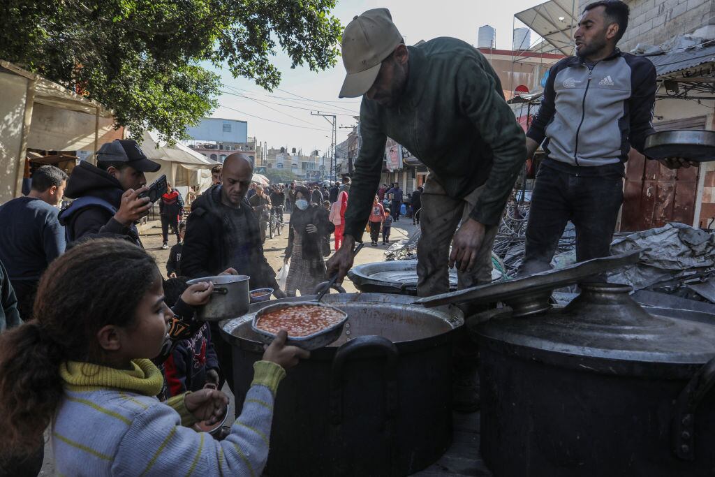 Voluntarios entregan comida a palestinos desplazados en la zona sur de la Franja de Gaza, territorio de Palestina atacado por Israel.