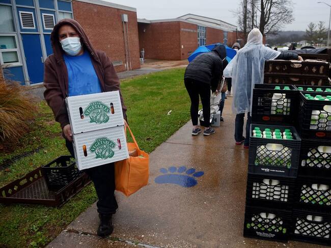 Las personas reciben cajas con comida en la ciudad de Baltimore