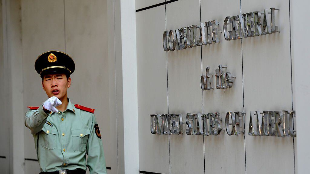 A Chinese paramilitary policeman gestures to photographers at the entrance to the US consulate in Chengdu, southwest China's Sichuan province on September 17, 2012, where Wang Lijun seeked refuge earlier this year, kicking off the scandal that brought down high-profile Communist leader Bo Xilai and led to his wife Gu Kailai's conviction for murder. Wang who was Bo's former right-hand man, will go on trial in Chengdu on September 18, the latest stage in a scandal that has rocked China's Communist party before a once-a-decade power handover. AFP PHOTO / GOH CHAI HIN (Photo credit should read GOH CHAI HIN/AFP/GettyImages)