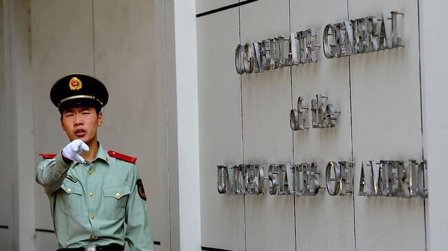 A Chinese paramilitary policeman gestures to photographers at the entrance to the US consulate in Chengdu, southwest China's Sichuan province on September 17, 2012, where Wang Lijun seeked refuge earlier this year, kicking off the scandal that brought down high-profile Communist leader Bo Xilai and led to his wife Gu Kailai's conviction for murder. Wang who was Bo's former right-hand man, will go on trial in Chengdu on September 18, the latest stage in a scandal that has rocked China's Communist party before a once-a-decade power handover. AFP PHOTO / GOH CHAI HIN (Photo credit should read GOH CHAI HIN/AFP/GettyImages)