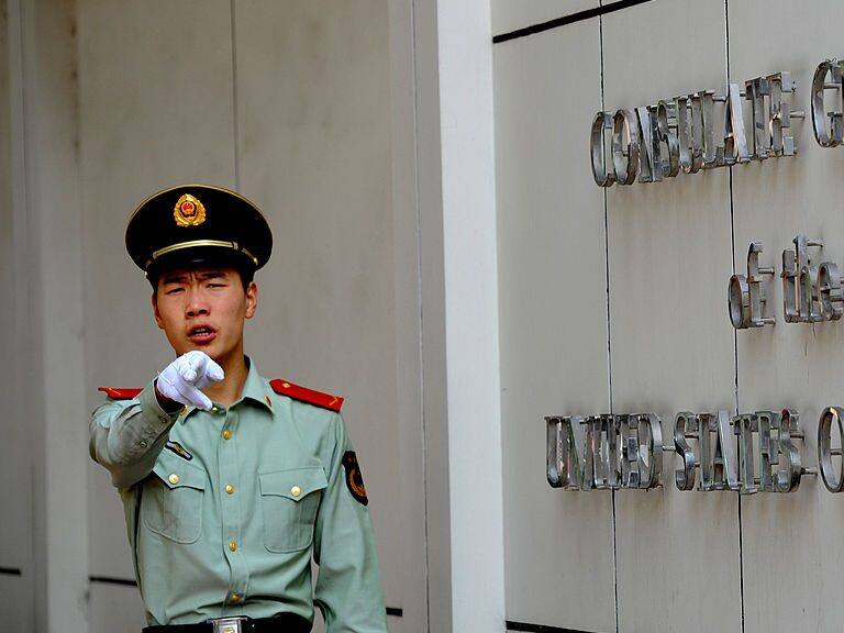 A Chinese paramilitary policeman gestures to photographers at the entrance to the US consulate in Chengdu, southwest China&#039;s Sichuan province on September 17, 2012, where Wang Lijun seeked refuge earlier this year, kicking off the scandal that brought down high-profile Communist leader Bo Xilai and led to his wife Gu Kailai&#039;s conviction for murder. Wang who was Bo&#039;s former right-hand man, will go on trial in Chengdu on September 18, the latest stage in a scandal that has rocked China&#039;s Communist party before a once-a-decade power handover. AFP PHOTO / GOH CHAI HIN        (Photo credit should read GOH CHAI HIN/AFP/GettyImages)