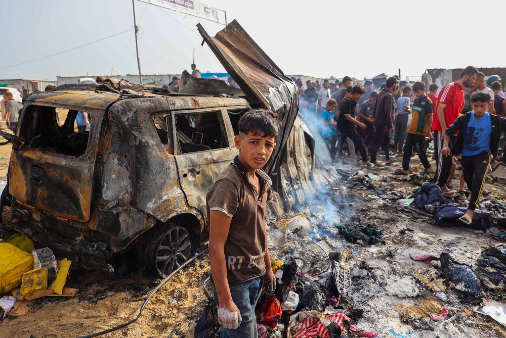TOPSHOT - EDITORS NOTE: Graphic content / Palestinians gather at the site of an Israeli strike on a camp area housing internally displaced people in Rafah on May 27, 2024, amid ongoing battles between Israel and the Palestinian Hamas militant group. Hamas and the Palestinian Authority said Israeli strikes on a centre for displaced people killed dozens near the southern city of Rafah on May 26, while the Israeli army said it had targeted Hamas militants. (Photo by Eyad BABA / AFP) (Photo by EYAD BABA/AFP via Getty Images)