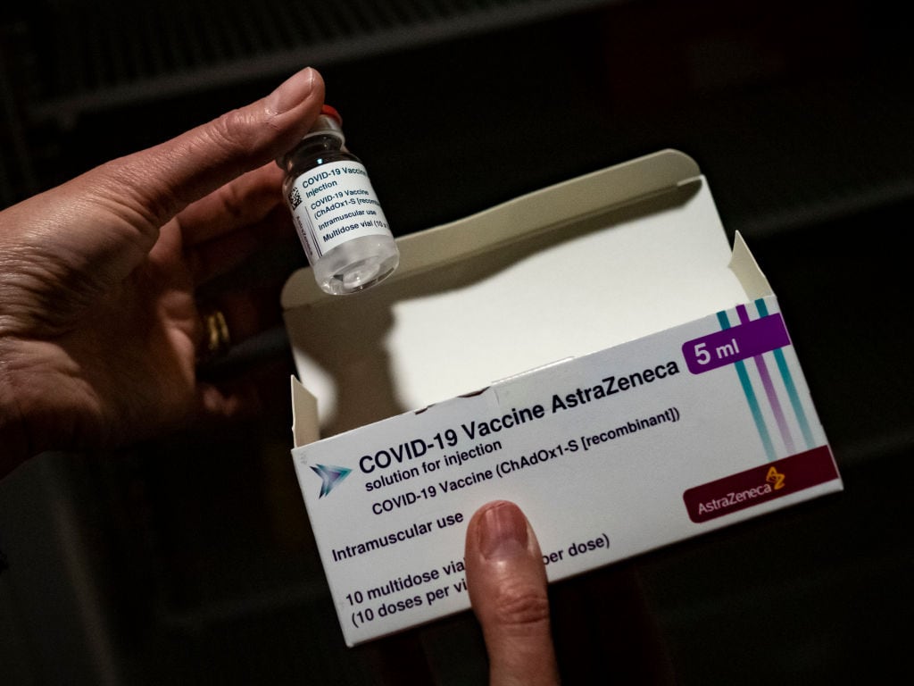 Una persona sostiene una dosis de la vacuna de Oxford-AstraZeneca