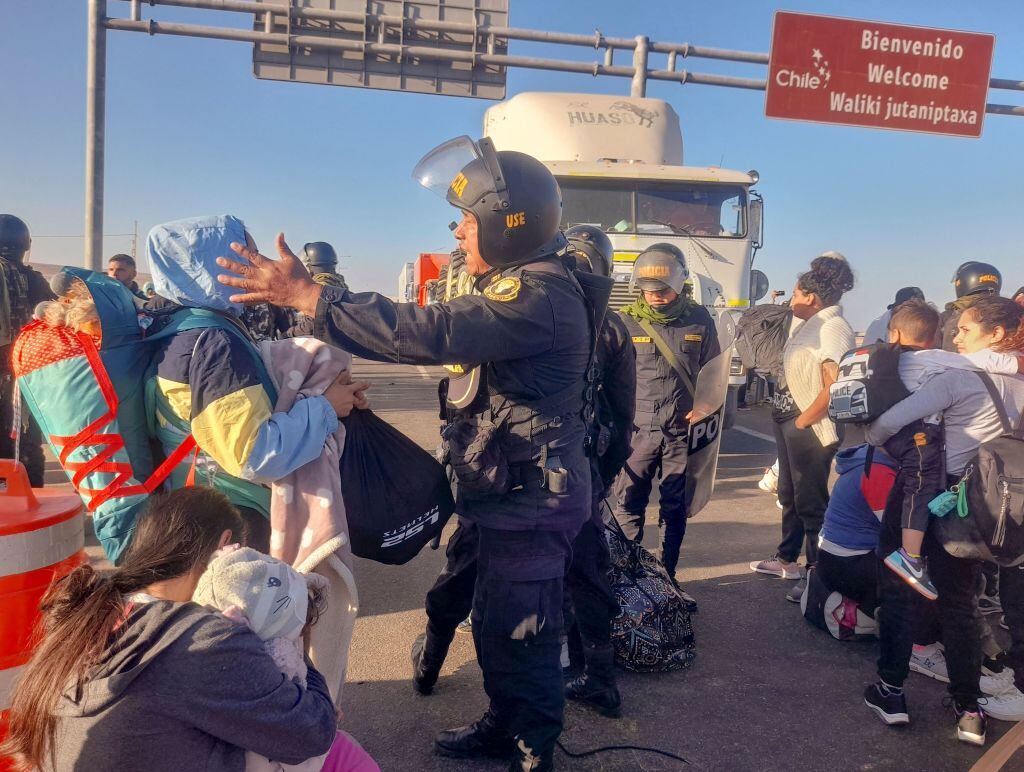 Policías de Perú ante migrantes en la frontera con Chile cerca de Tacna