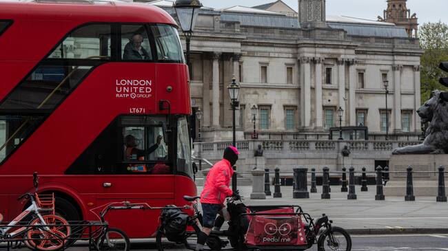 LONDON, ENGLAND - APRIL 17 : A bus driver wears a face mask whilst driving past Trafalgar Square on April 17, 2020 in London, United Kingsom. In a press conference on Thursday, First Secretary of State Dominic Raab announced that the lockdown will remain in place for at least 3 more weeks. The Coronavirus (COVID-19) pandemic has spread to many countries across the world, claiming over 140,000 lives and infecting more than 2 million people. (Photo by Chris J Ratcliffe/Getty Images)