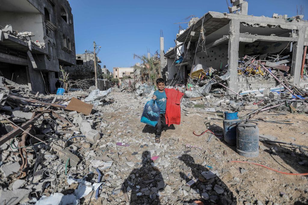Niño palestino camina entre escombros que dejan los ataques de Israel en Gaza