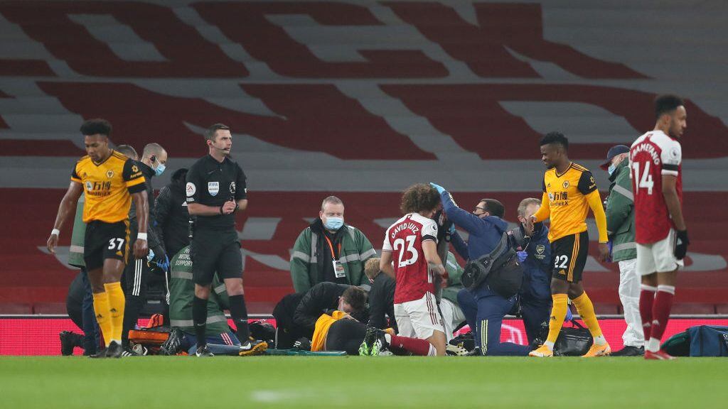 LONDON, ENGLAND - NOVEMBER 29: Raul Jimenez of Wolverhampton Wanderers and David Luiz of Arsenal receive treatment after a clash of heads  during the Premier League match between Arsenal and Wolverhampton Wanderers at Emirates Stadium on November 29, 2020 in London, United Kingdom. Sporting stadiums around the UK remain under strict restrictions due to the Coronavirus Pandemic as Government social distancing laws prohibit fans inside venues resulting in games being played behind closed doors. (Photo by James Williamson - AMA/Getty Images)