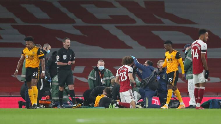 LONDON, ENGLAND - NOVEMBER 29: Raul Jimenez of Wolverhampton Wanderers and David Luiz of Arsenal receive treatment after a clash of heads during the Premier League match between Arsenal and Wolverhampton Wanderers at Emirates Stadium on November 29, 2020 in London, United Kingdom. Sporting stadiums around the UK remain under strict restrictions due to the Coronavirus Pandemic as Government social distancing laws prohibit fans inside venues resulting in games being played behind closed doors. (Photo by James Williamson - AMA/Getty Images)