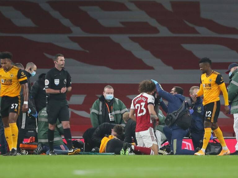 LONDON, ENGLAND - NOVEMBER 29: Raul Jimenez of Wolverhampton Wanderers and David Luiz of Arsenal receive treatment after a clash of heads  during the Premier League match between Arsenal and Wolverhampton Wanderers at Emirates Stadium on November 29, 2020 in London, United Kingdom. Sporting stadiums around the UK remain under strict restrictions due to the Coronavirus Pandemic as Government social distancing laws prohibit fans inside venues resulting in games being played behind closed doors. (Photo by James Williamson - AMA/Getty Images)