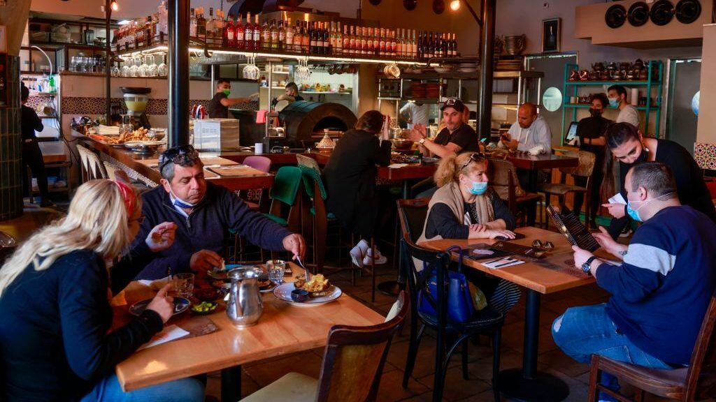 People eat at the Hamotzi restaurant in Jerusalem, on March 7, 2021, after Israel reopened restaurants, bars and cafes to vaccinated "green pass" holders. - Israel took another step towards post-pandemic normalcy, with about 40 percent of the population fully inoculated against the coronavirus. (Photo by MENAHEM KAHANA / AFP) (Photo by MENAHEM KAHANA/AFP via Getty Images)