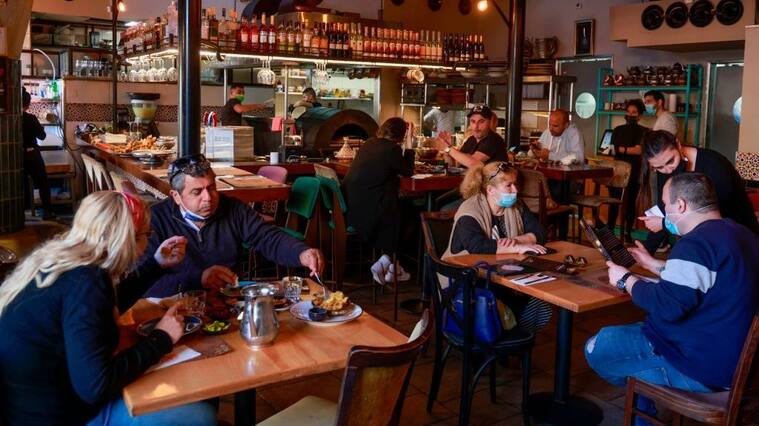People eat at the Hamotzi restaurant in Jerusalem, on March 7, 2021, after Israel reopened restaurants, bars and cafes to vaccinated "green pass" holders. - Israel took another step towards post-pandemic normalcy, with about 40 percent of the population fully inoculated against the coronavirus. (Photo by MENAHEM KAHANA / AFP) (Photo by MENAHEM KAHANA/AFP via Getty Images)