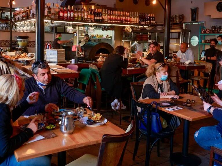 People eat at the Hamotzi restaurant in Jerusalem, on March 7, 2021, after Israel reopened restaurants, bars and cafes to vaccinated "green pass" holders. - Israel took another step towards post-pandemic normalcy, with about 40 percent of the population fully inoculated against the coronavirus. (Photo by MENAHEM KAHANA / AFP) (Photo by MENAHEM KAHANA/AFP via Getty Images)