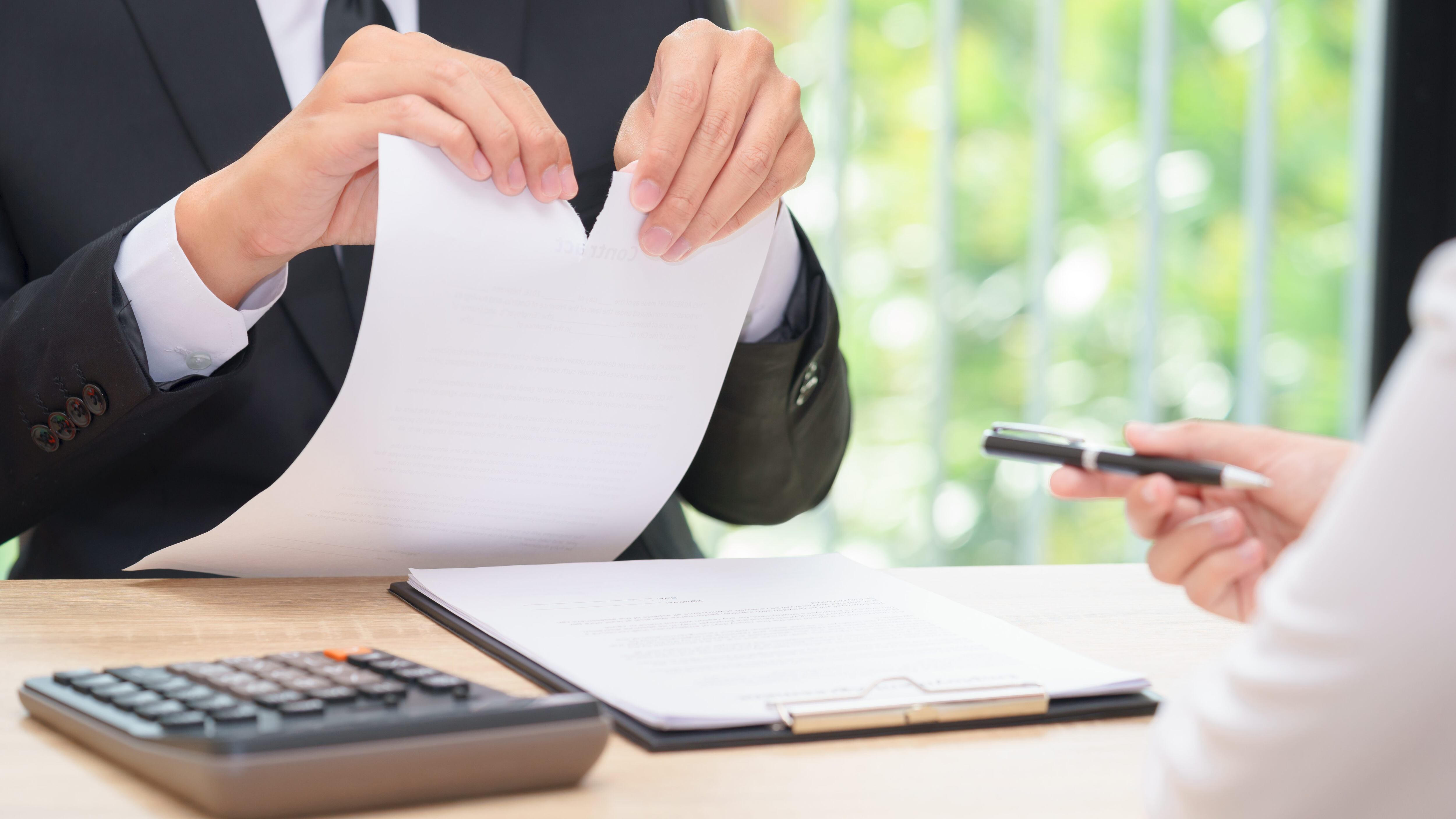 Hands of businessman ripping agreement paper when woman giving a pen for signing, break the rules - failure business concept