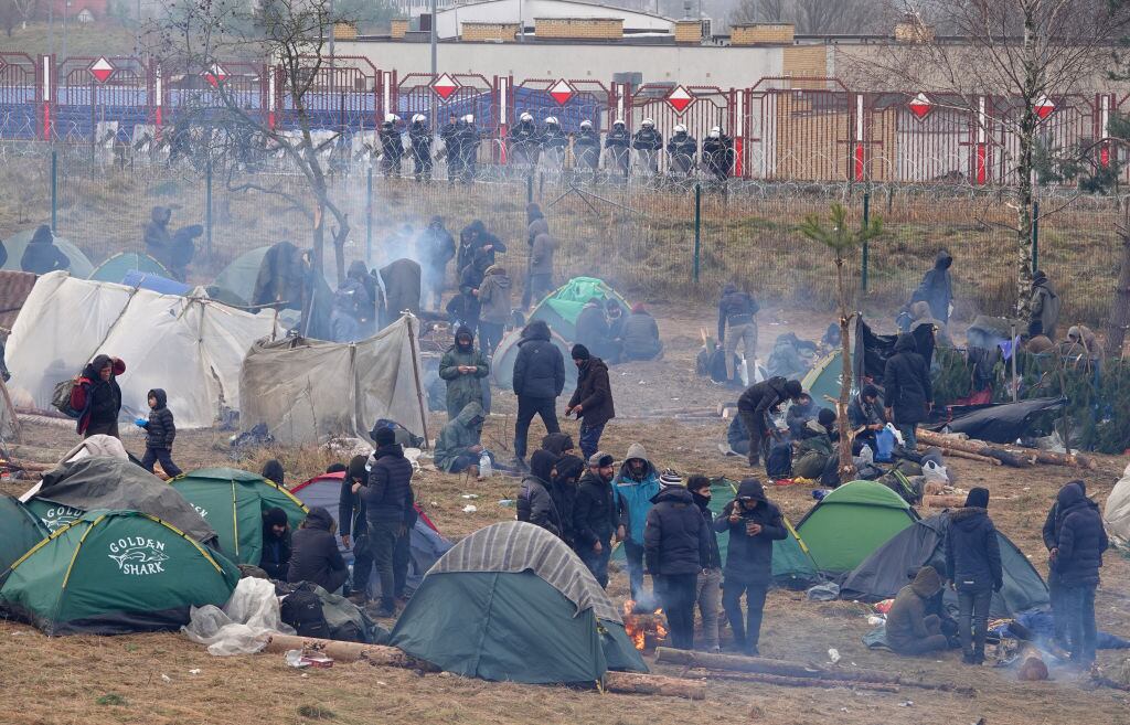 Migrantes descansan en un campamento en la frontera de Bielorrusia y Polonia