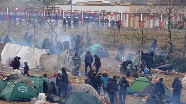 Migrantes descansan en un campamento en la frontera de Bielorrusia y Polonia