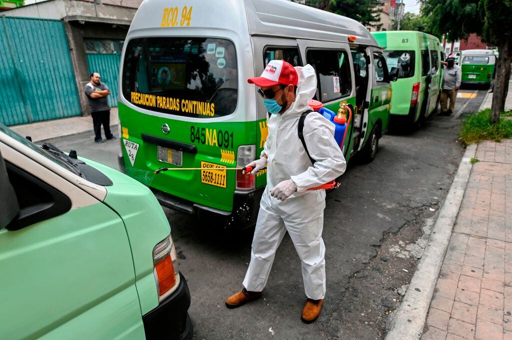 Trabajadores desinfectan buses del transporte público en México