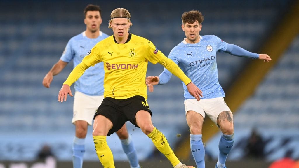 MANCHESTER, ENGLAND - APRIL 06: Erling Haaland of Borussia Dortmund battles for possession with John Stones of Manchester City during the UEFA Champions League Quarter Final match between Manchester City and Borussia Dortmund at Etihad Stadium on April 06, 2021 in Manchester, England. Sporting stadiums around the UK remain under strict restrictions due to the Coronavirus Pandemic as Government social distancing laws prohibit fans inside venues resulting in games being played behind closed doors. (Photo by Michael Regan/Getty Images)