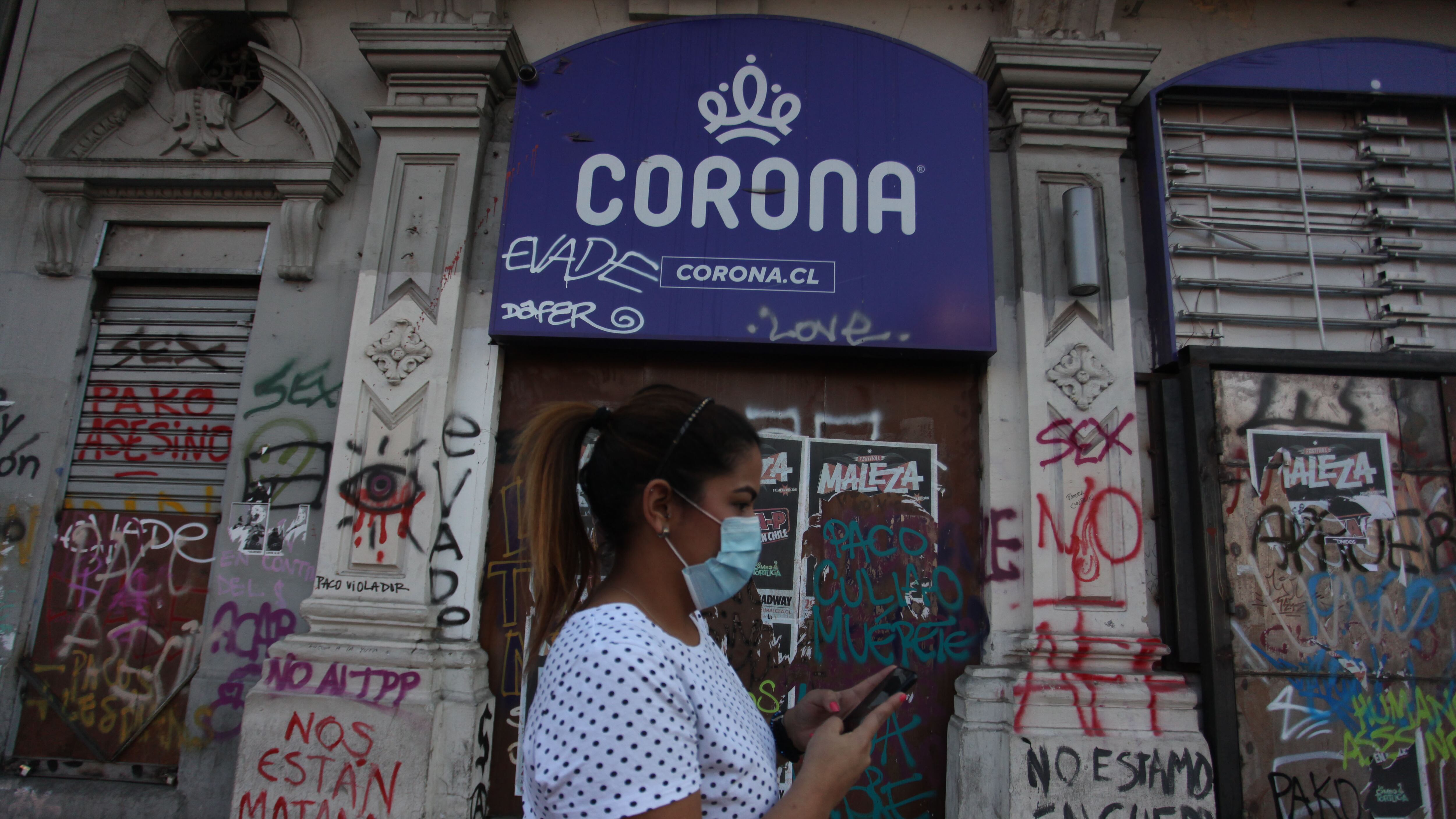 07 DE MAYO 2020 / SANTIAGO
Personas transitan por calle Alameda a las afueras de un local con la publicidad de la tienda comercial Corona, empresa que solicitaro acogerse a la Ley de Protección del Empleo, tras la pandemia mundial por Covid-19. Santiago
FOTO: AILEN DIAZ/AGENCIAUNO