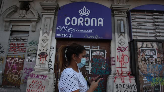 07 DE MAYO 2020 / SANTIAGO
Personas transitan por calle Alameda a las afueras de un local con la publicidad de la tienda comercial Corona, empresa que solicitaro acogerse a la Ley de Protección del Empleo, tras la pandemia mundial por Covid-19. Santiago
FOTO: AILEN DIAZ/AGENCIAUNO