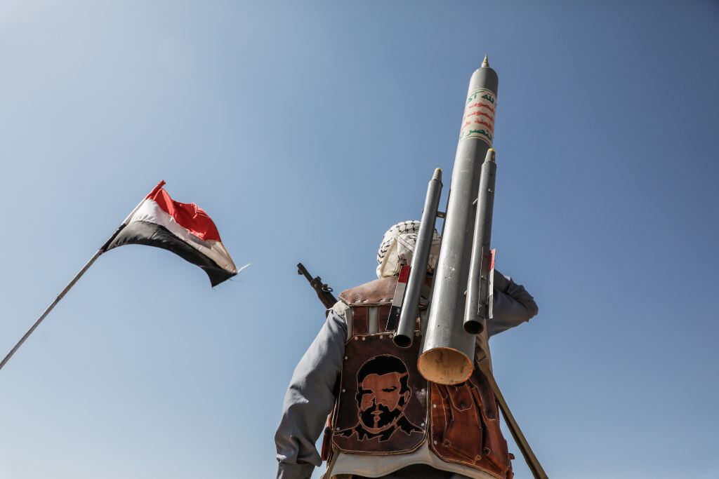 Un miembro del grupo rebelde llamados hutíes camina por Saná en Yemen portando un proyectil, en medio del conflicto con Estados Unidos.