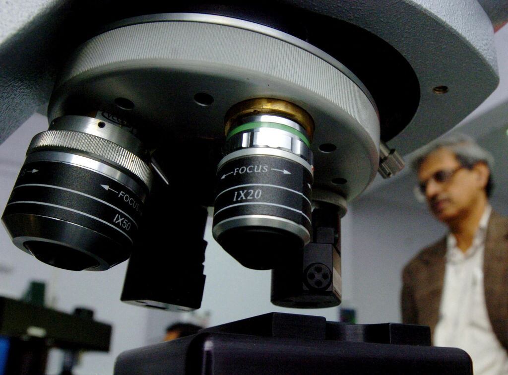 An Indian scientist takes a close look at an Optical Profiling System microscope at a nanotechnology laboratory at the Jawaharlal Nehru Center for Advanced Scientific Research (JNCASR), in Bangalore 27 July 2005.  Veeco Instruments Inc., a leading global supplier of instruments to the nanoscience community, joined hands with JNCASR to set up the nanoscience center for advanced studies. (Photo by DIBYANGSHU SARKAR / AFP) (Photo by DIBYANGSHU SARKAR/AFP via Getty Images)