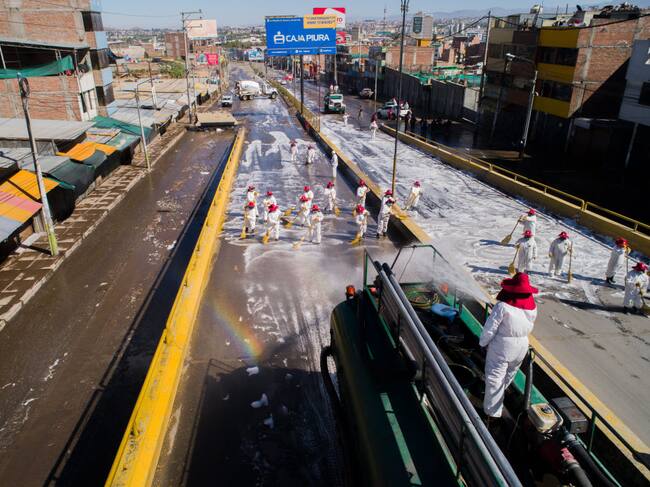 Trabajadores desinfectan una autopista en Perú