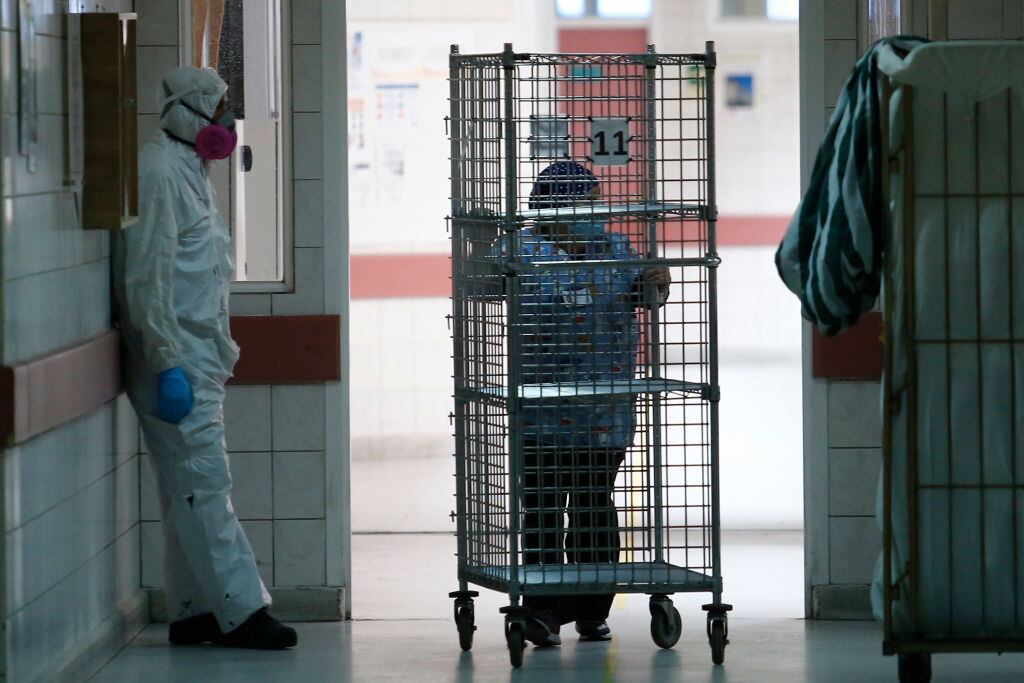SANTIAGO, CHILE - JUNE 16: Health worker rests as a team member carries supplies during the coronavirus pandemic at San Jose Hospital on June 16, 2020 in Santiago, Chile. On Monday, President Piñera extended the State of Catastrophe for 90 days to better control the outbreak of COVID-19 in the country. (Photo by Marcelo Hernandez/Getty Images)