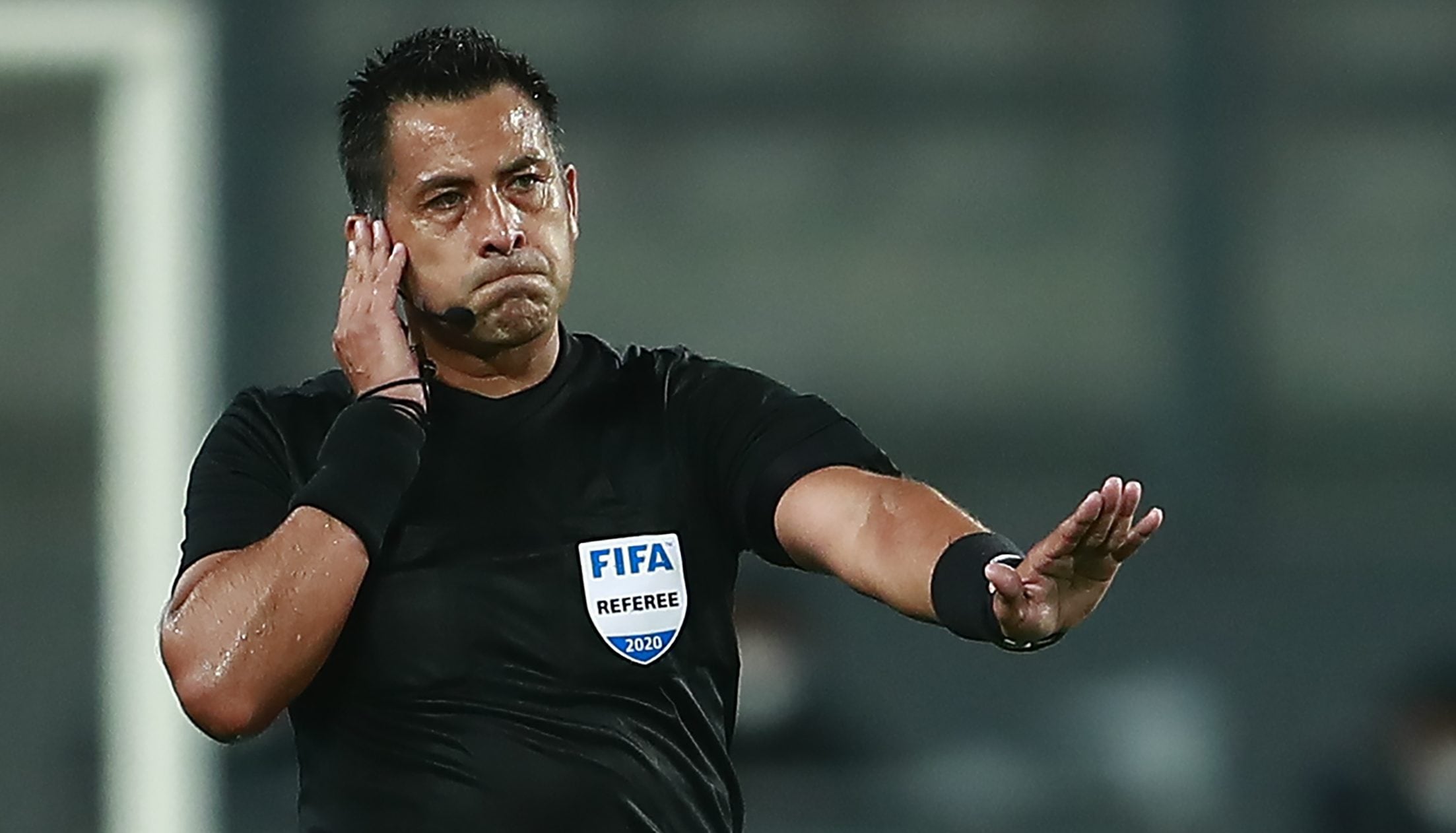 Chilean referee Julio Bascunan consults the VAR as he conducts the 2022 FIFA World Cup South American qualifier football match between Peru and Brazil at the National Stadium in Lima, on October 13, 2020, amid the COVID-19 novel coronavirus pandemic. (Photo by Daniel APUY / various sources / AFP) (Photo by DANIEL APUY/AFP via Getty Images)