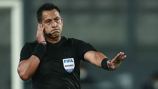 Chilean referee Julio Bascunan consults the VAR as he conducts the 2022 FIFA World Cup South American qualifier football match between Peru and Brazil at the National Stadium in Lima, on October 13, 2020, amid the COVID-19 novel coronavirus pandemic. (Photo by Daniel APUY / various sources / AFP) (Photo by DANIEL APUY/AFP via Getty Images)