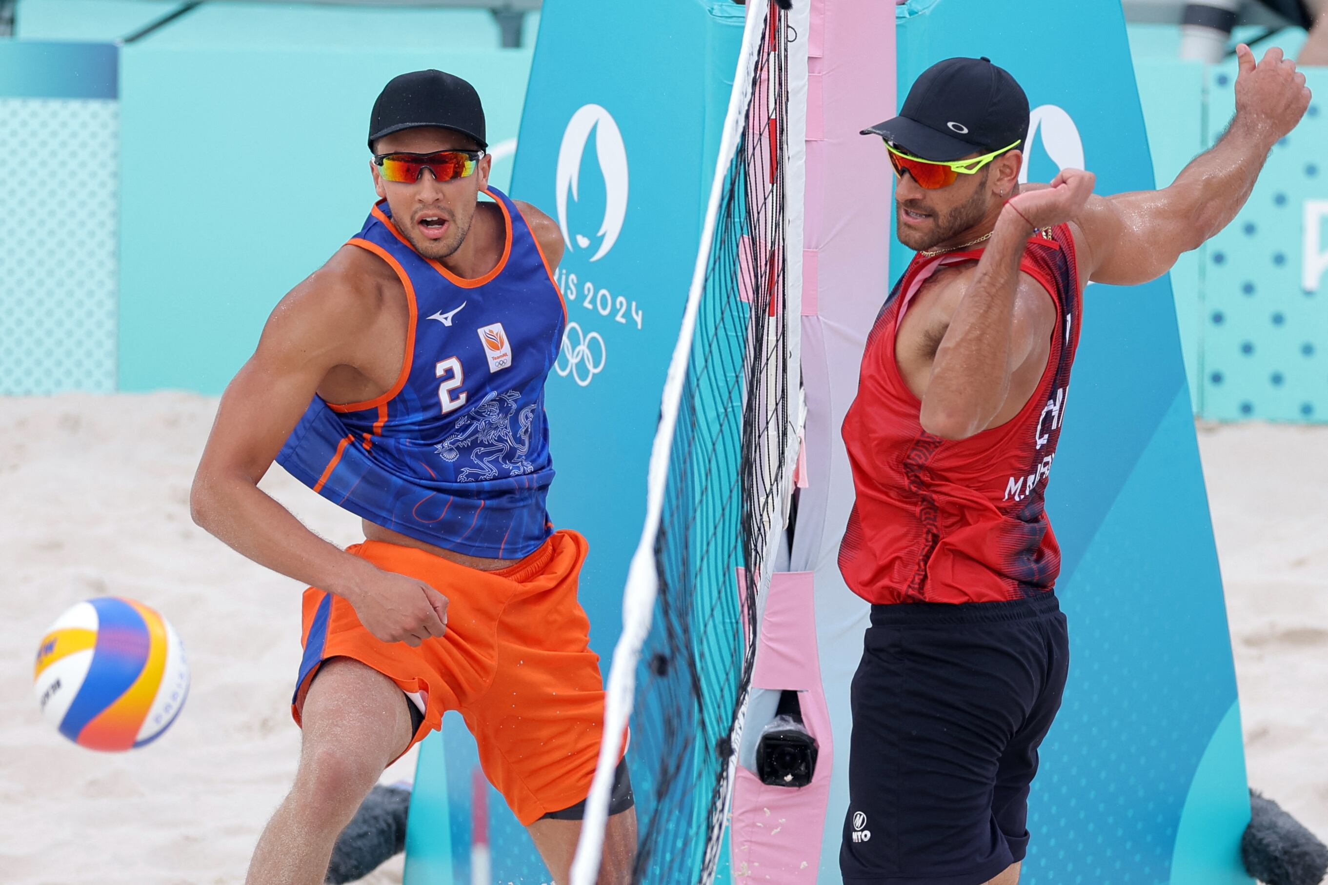 Netherlands' #02 Matthew Immers and Chile's #01 Marco Grimalt watch the ball in the men's pool B beach volleyball match between Netherlands and Chile during the Paris 2024 Olympic Games at the Eiffel Tower Stadium in Paris on July 31, 2024. (Photo by Thomas SAMSON / AFP) (Photo by THOMAS SAMSON/AFP via Getty Images)