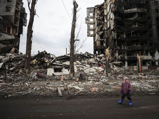 Un niño camina ante un edificio destruido en la ciudad de Borodianka