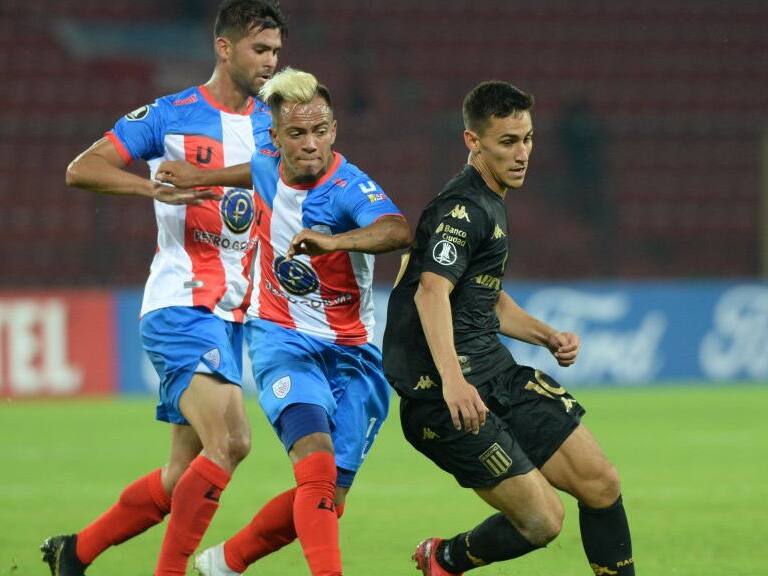 Argentina's Racing Club midfielder Matias Rojas and Venezuela's Estudiantes de Merida midfielder Christian Flores (C) vie for the ball during their Copa Libertadores football match, at the Metropolitano stadium in Merida on March 5, 2020. (Photo by CARLOS EDUARDO RAMIREZ / AFP) (Photo by CARLOS EDUARDO RAMIREZ/AFP via Getty Images)
