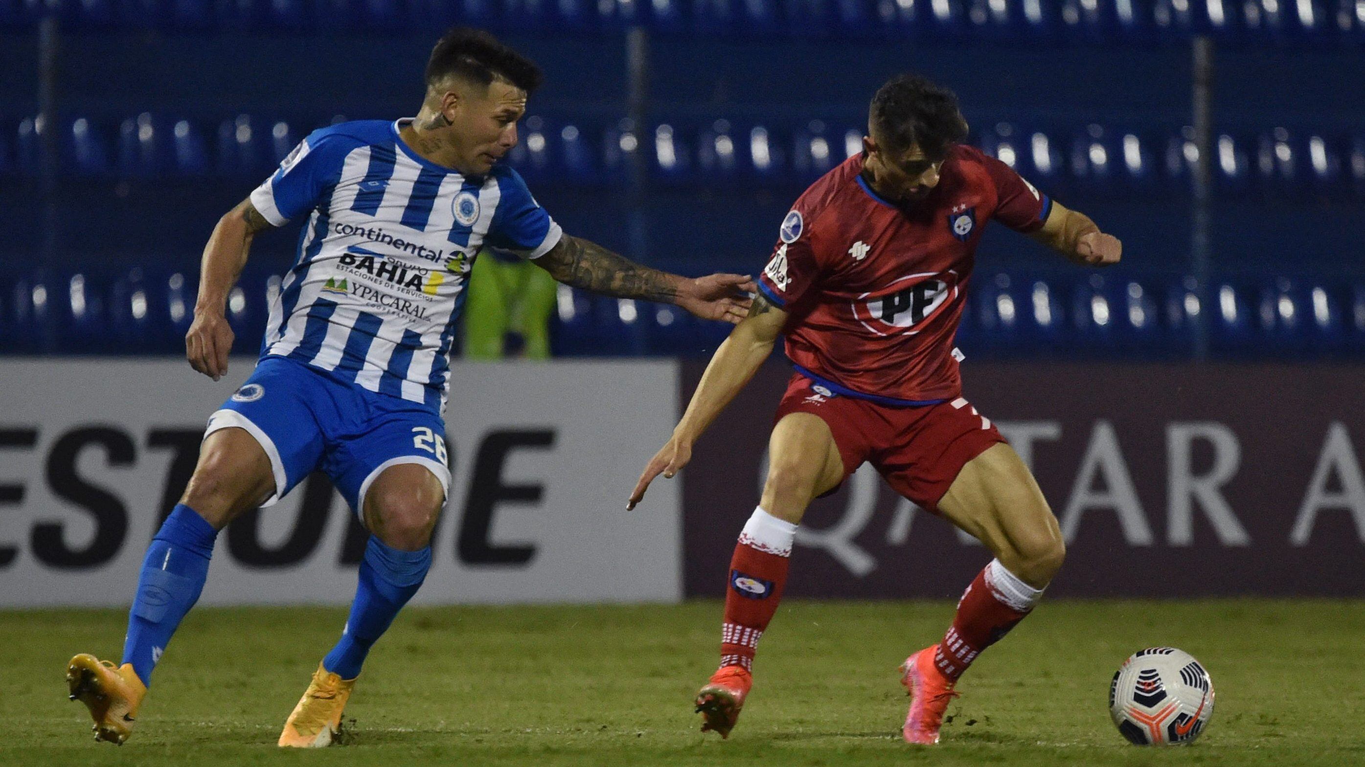 Paraguay's 12 de Octubre Víctor Ayala (L) and Chile's Huachipato Argentine Walter Mazzantti vie for the ball during the Copa Sudamericana football tournament group stage match at the Luis Alfonso Giagni stadium in Villa Elisa, Paraguay, on May 12, 2021. (Photo by NORBERTO DUARTE / AFP) (Photo by NORBERTO DUARTE/AFP via Getty Images)